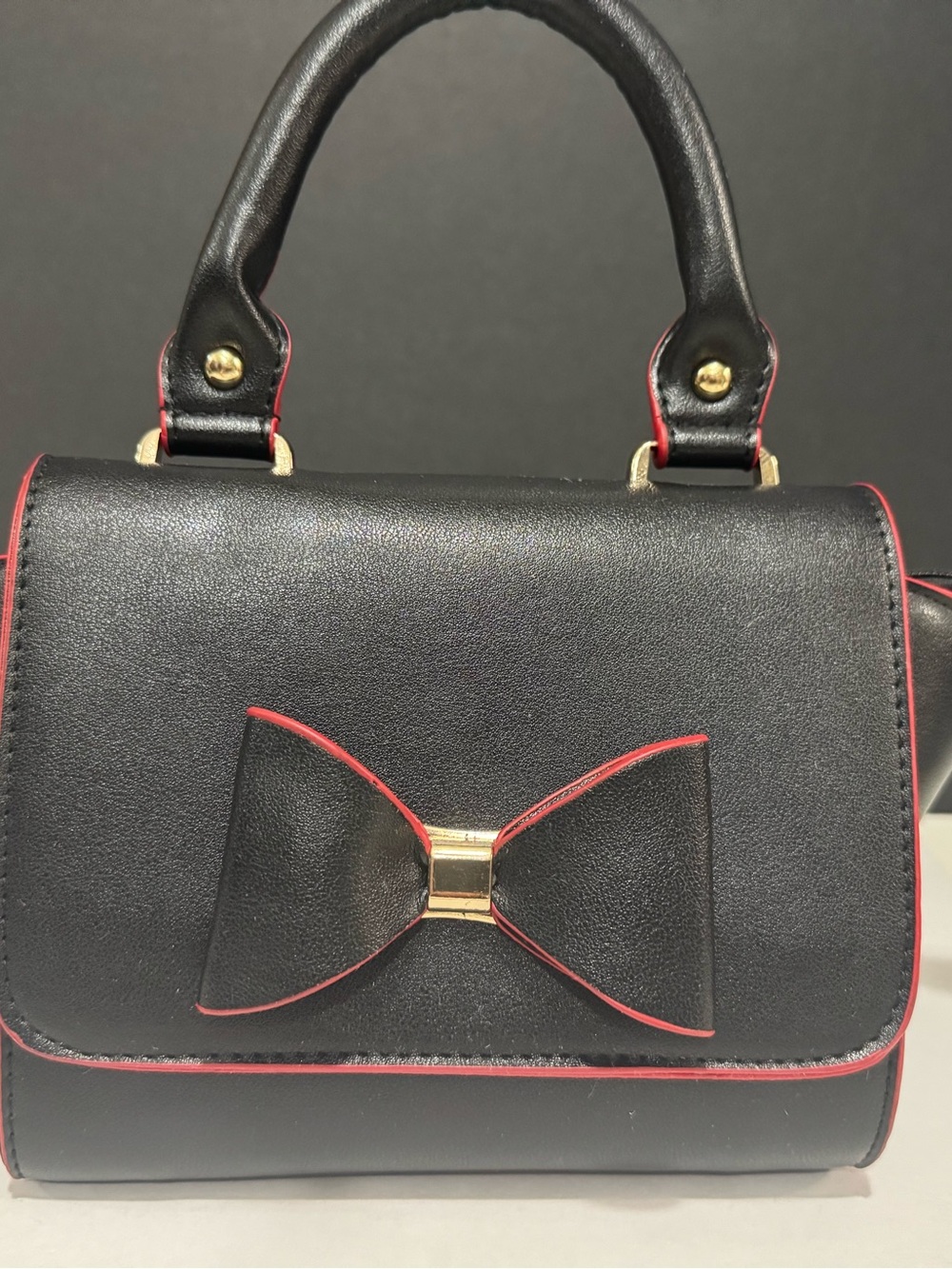 Olivia Miller Black Satchel with Red Trim and Gold Bow Accent